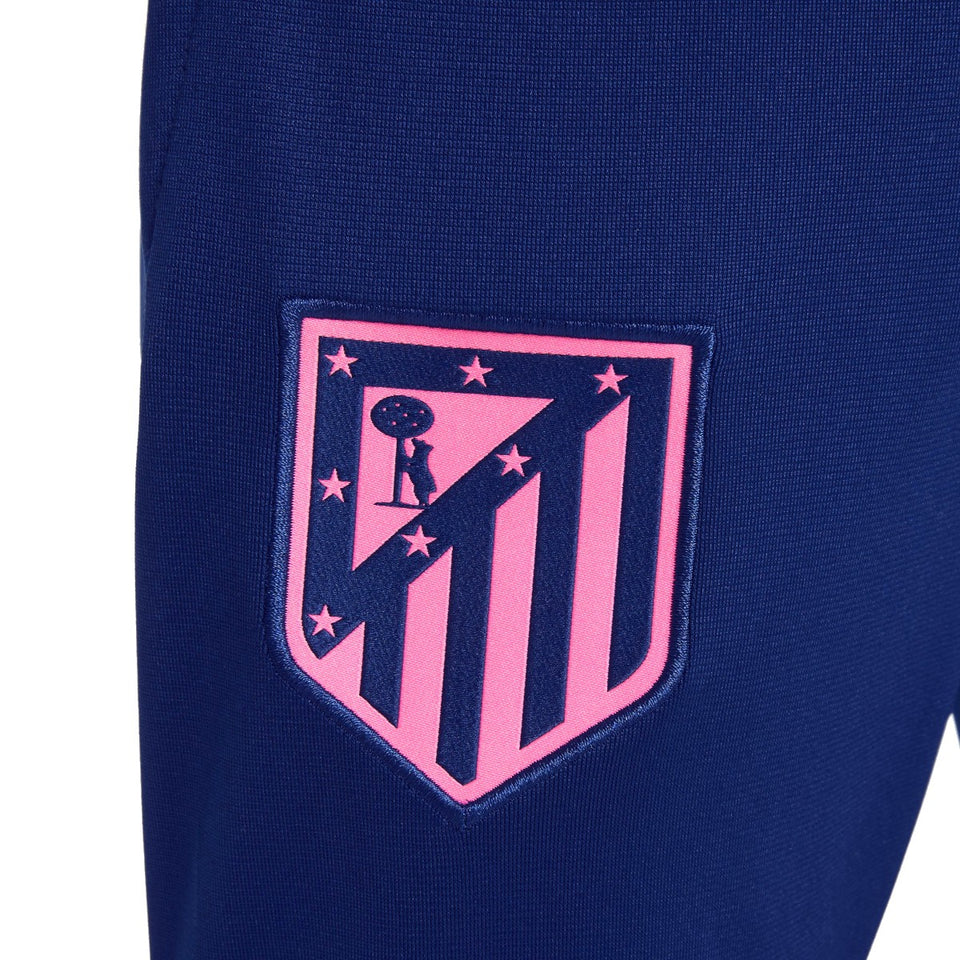 Close-up of pink Atletico Madrid logo on blue fabric of kids Atletico Madrid tracksuit 2024