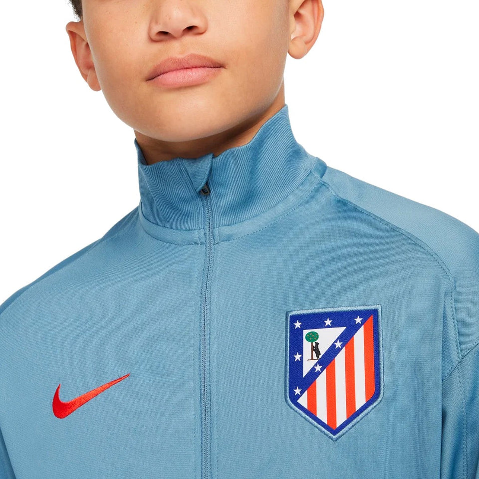 Close-up of a boy wearing a blue kids Atletico Madrid tracksuit jacket with Nike logo