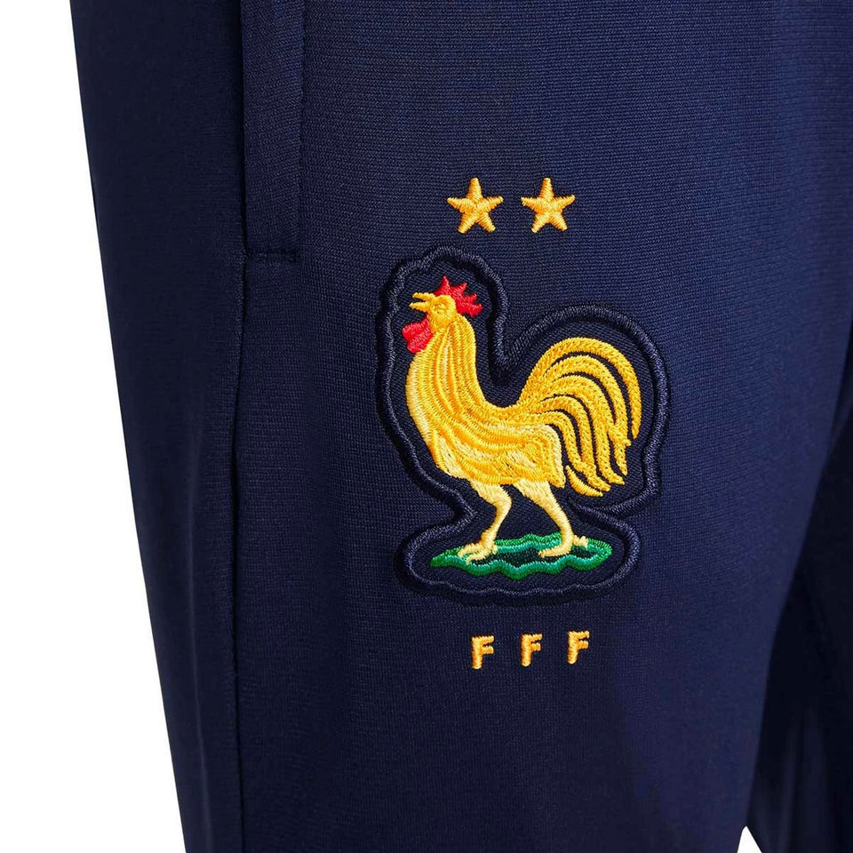 Close-up of kids France soccer tracksuit 2024 navy blue pants with yellow rooster emblem and FFF logo