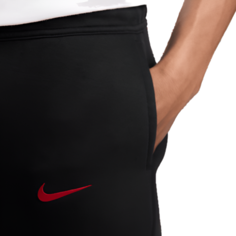 Liverpool FC black tech fleece pants close up with hand in pocket and red Nike swoosh on black fabric
