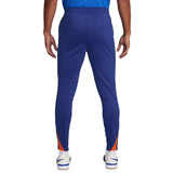 Back view of Nike Netherlands training tracksuit blue pants with orange accents and white sneakers