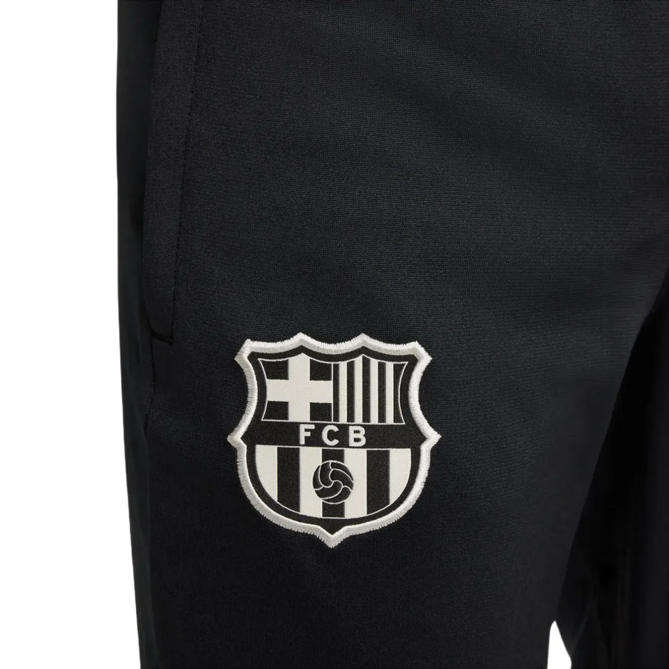 Close-up of official kids Nike Barca tracksuit black pants with FCB logo on SoccerTracksuits.com