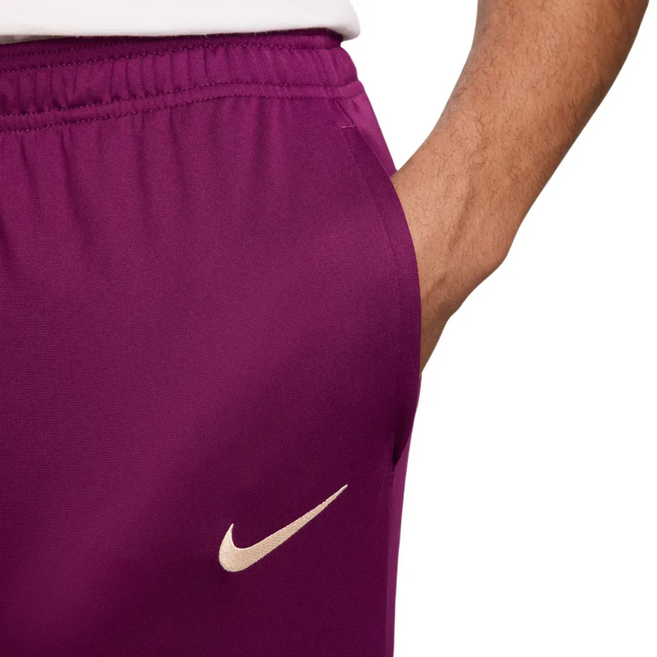 Close-up of purple official PSG Nike tracksuit 2024 pants with white Nike logo and elastic waistband