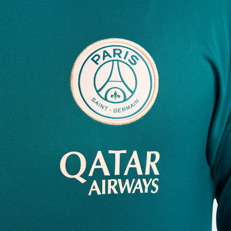 Close-up of official PSG Nike tracksuit 2024 logo and Qatar Airways sponsor on teal fabric