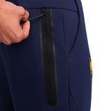 Close-up of hand adjusting zipper pocket on navy Nike tech fleece tracksuit France 2024 pants