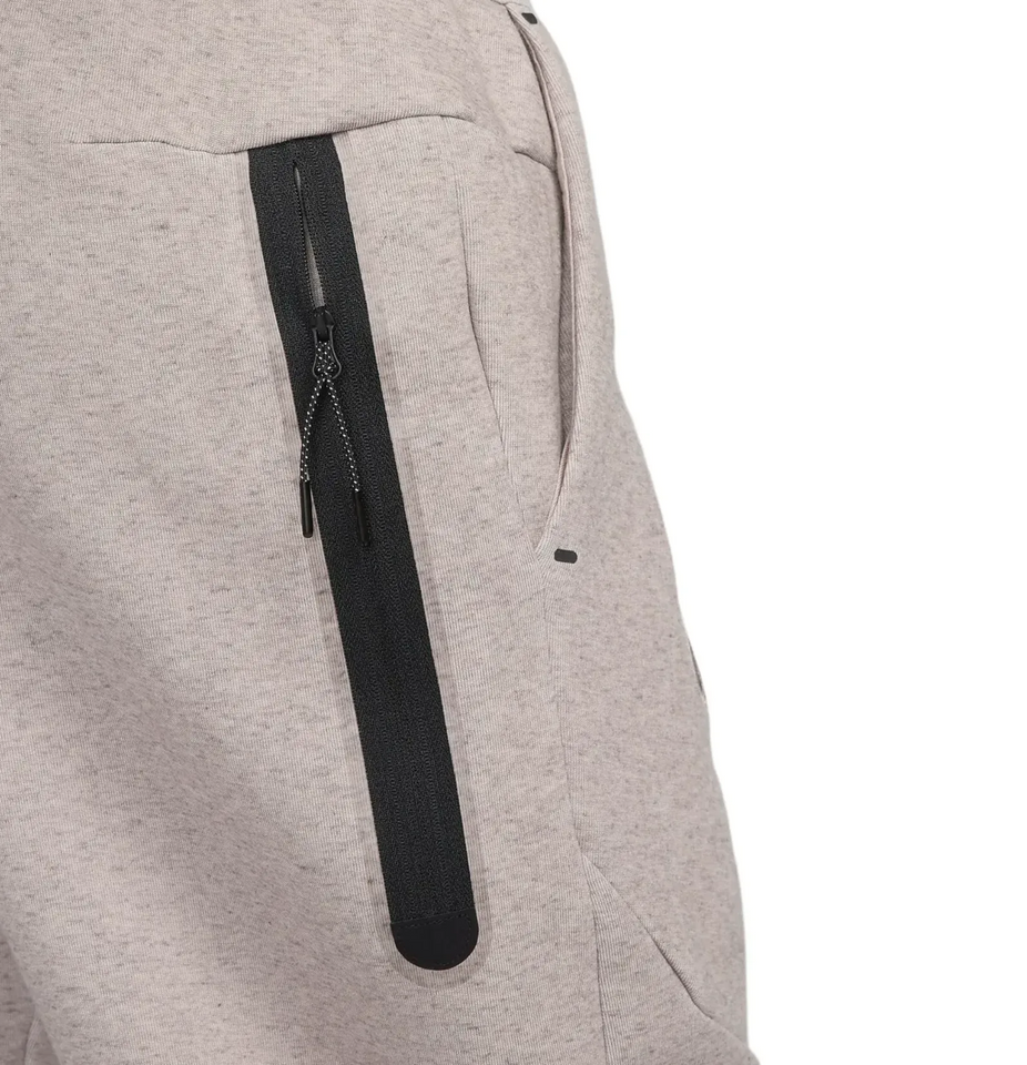 Close-up of beige Tottenham Hotspur Tech Fleece tracksuit pants with black zippered pocket