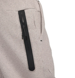 Close-up of beige Tottenham Hotspur Tech Fleece tracksuit pants with black zippered pocket