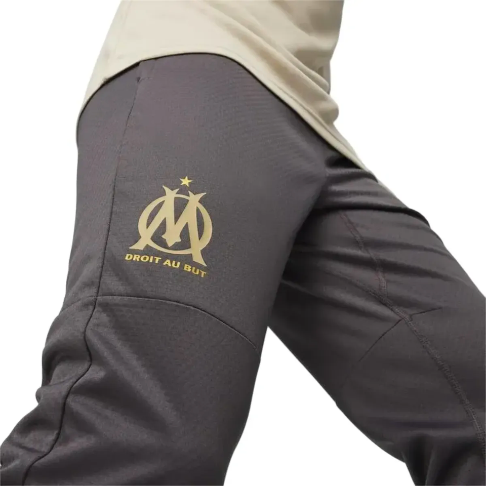 Close-up of Olympique Marseille gold training tracksuit 2024 showcasing the logo and design details.