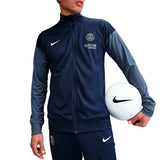 Model wearing Paris Saint-Germain 2025 soccer tracksuit with Nike logo and holding a soccer ball