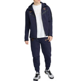 Man wearing navy blue PSG tech fleece tracksuit 2023 with zip-up hoodie and matching pants