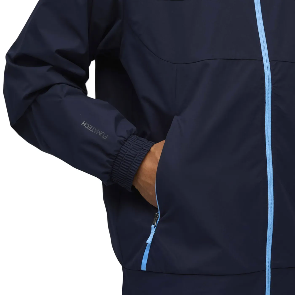Close-up of Puma Manchester City presentation tracksuit featuring a navy jacket with light blue zipper and cuffs