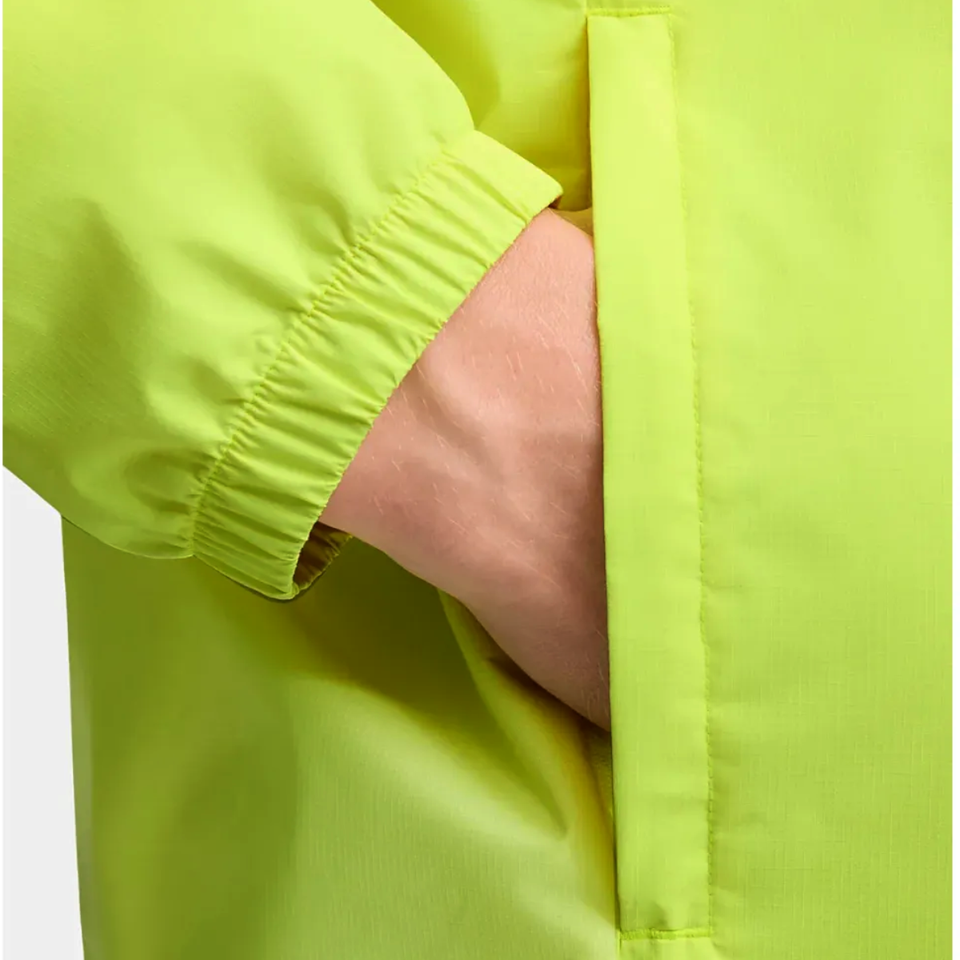 Close-up of a hand in the pocket of an Olympique Marseille rain jacket 2025 in bright green color