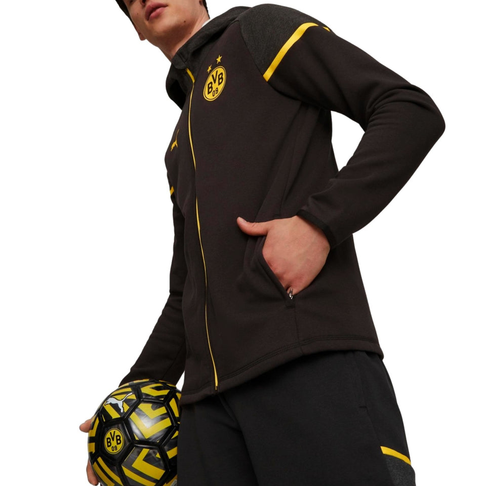 Puma Borussia Dortmund jacket black hoodie with yellow trim and BVB crest worn by model holding match ball