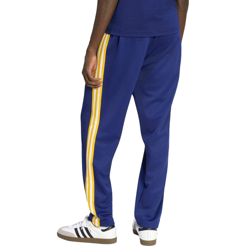 Blue Adidas Originals x Real Madrid tracksuit with yellow stripes on a white background