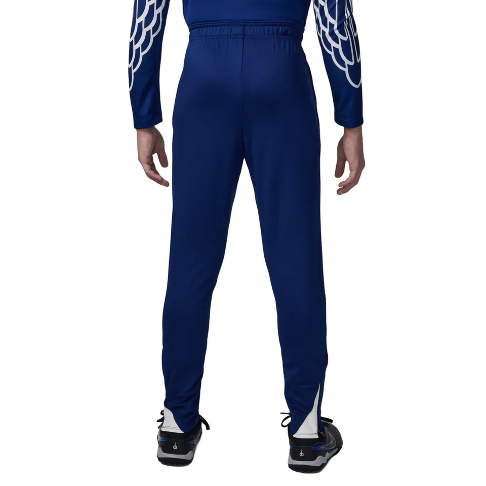 Back view of a boy wearing a red Jordan PSG training tracksuit for kids with blue accents