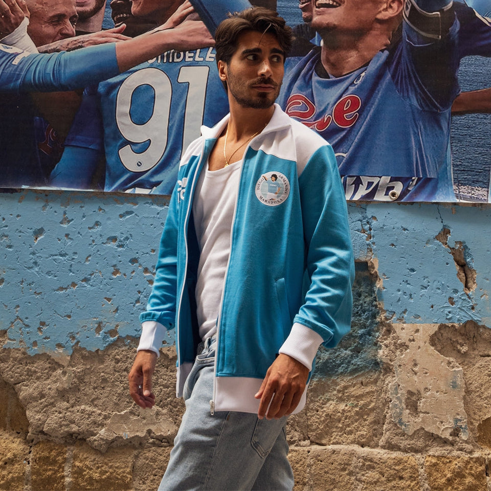 Man wearing SSC Napoli Maradona 1984 retro jacket - sky blue in a vibrant urban setting
