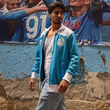 Man wearing SSC Napoli Maradona 1984 retro jacket - sky blue in a vibrant urban setting