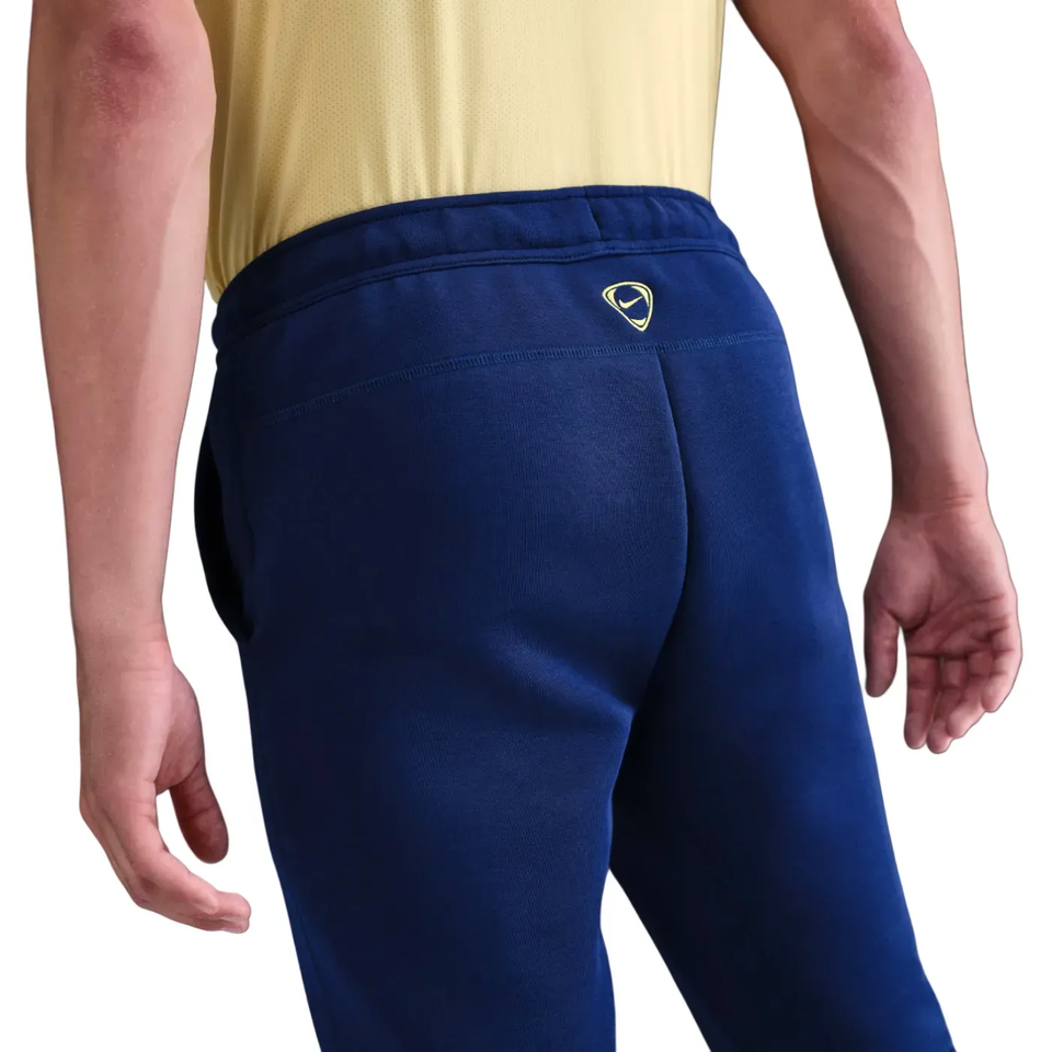 Back view of navy Nike tracksuit bottoms featuring Tottenham Hotspur UCL Tech Fleece design for comfort