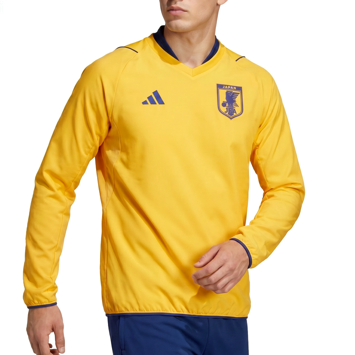 Person wearing a Japan yellow sports jersey with an Adidas logo on a white background