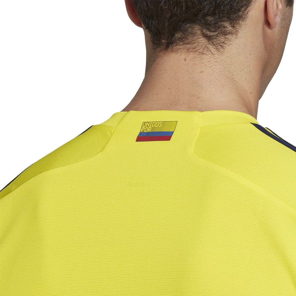 Colombia home soccer jersey 2022 featuring a vibrant yellow design and national flag detail on the neckline