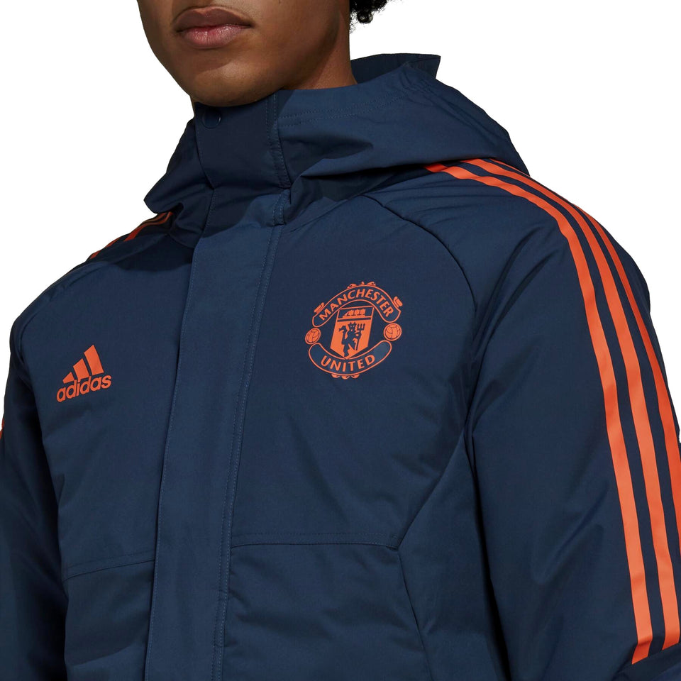 Manchester United bench parka jacket 2022 in navy with orange stripes and logo for stylish warmth