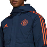 Manchester United bench parka jacket 2022 in navy with orange stripes and logo for stylish warmth