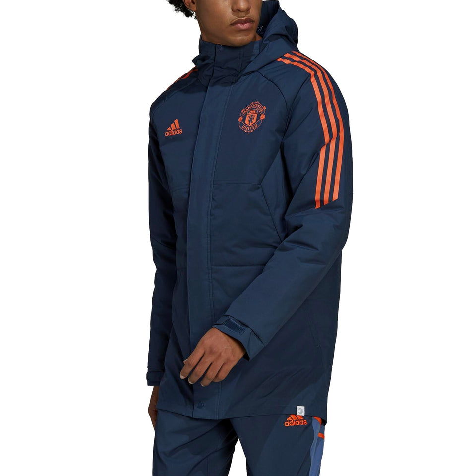 Manchester United bench parka jacket 2022 in navy blue with orange stripes and logo for fans