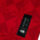Close-up of the Malta national soccer jersey 2022 tag displaying authenticity details in red fabric