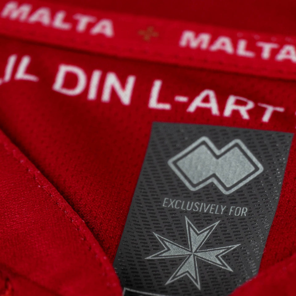 Close-up of the Malta national soccer jersey 2022 tag on a red tracksuit for soccer fans