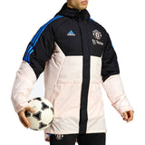 Manchester United down parka jacket 2023 in black and pink worn by a model holding a soccer ball