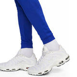 Close-up of white Nike sneakers worn with blue pants from Nike PSG soccer tracksuit buy Nike PSG soccer tracksuit online
