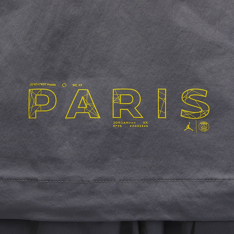 Close-up of yellow Paris graphic on grey Jordan PSG presentation suit fabric