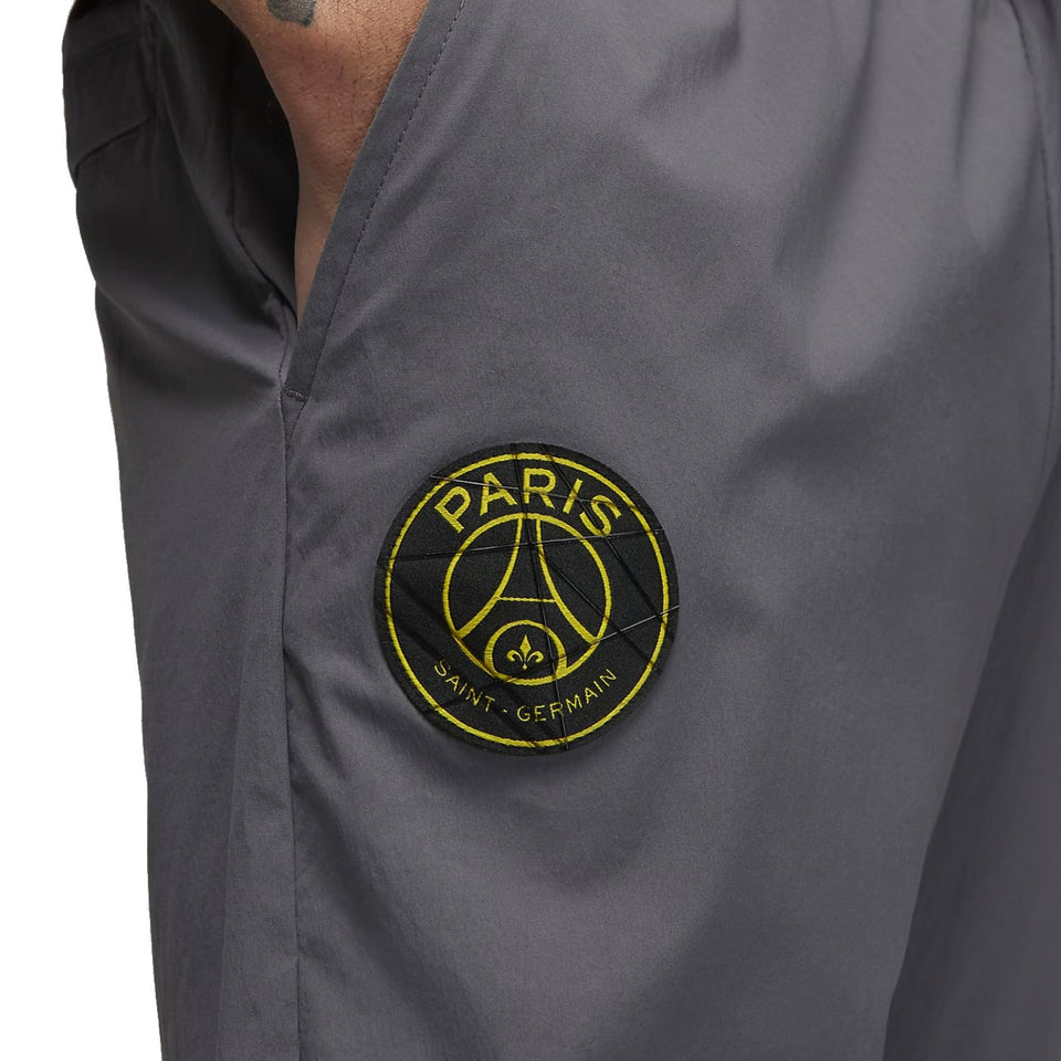 Close-up of grey Jordan PSG presentation suit pants with Paris Saint-Germain logo patch